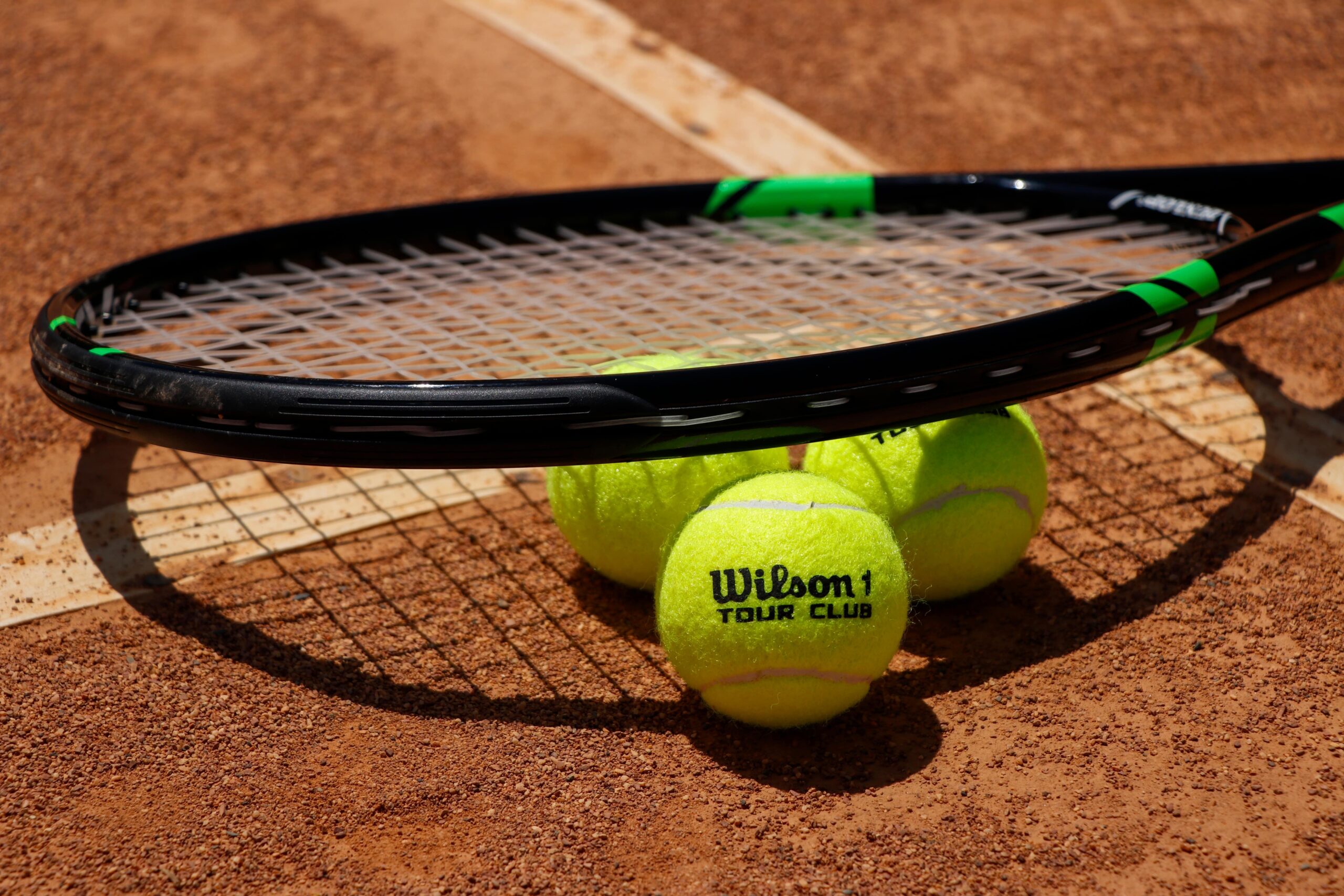 Tennis balls and racket on court