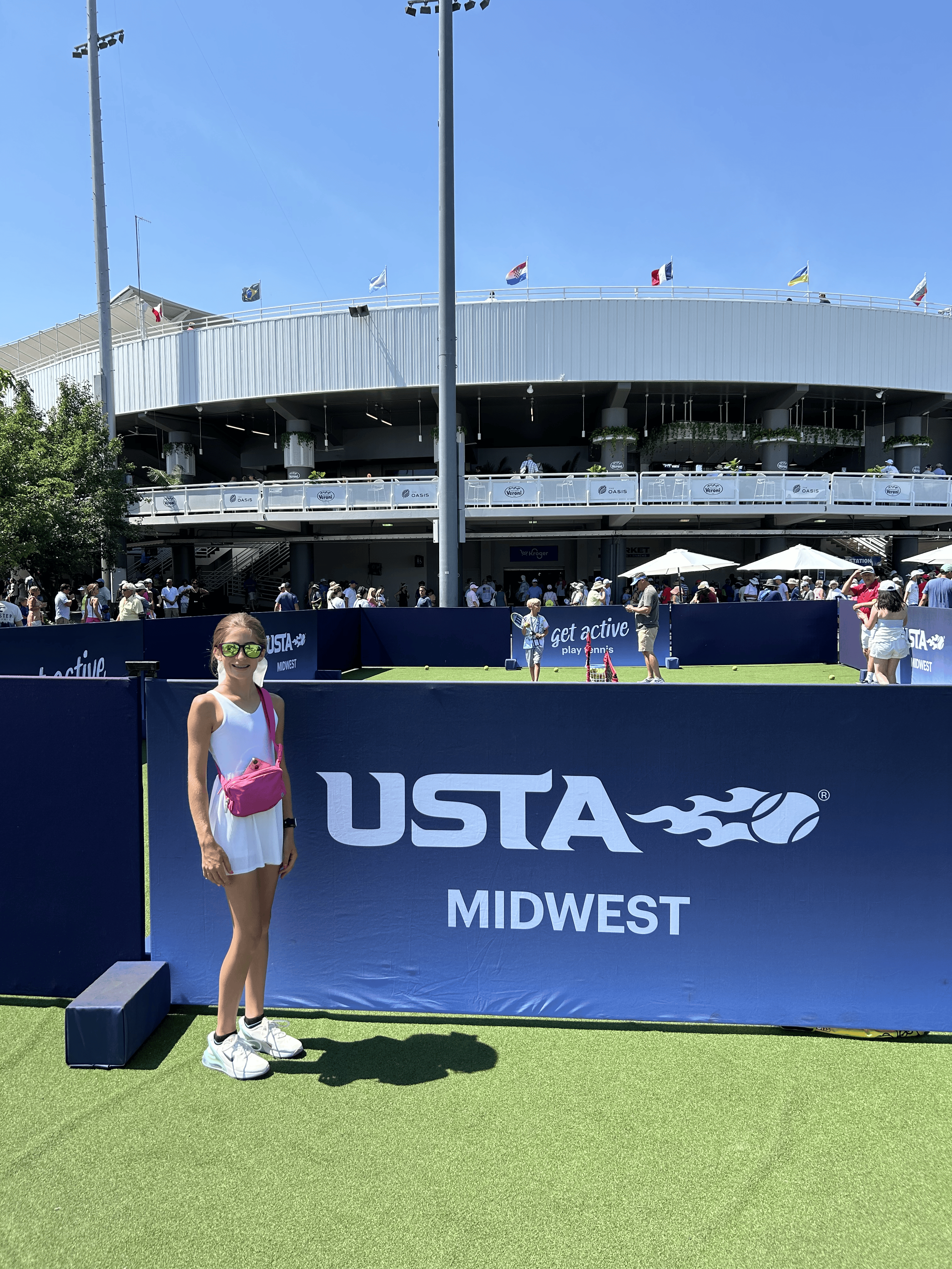 Young female tennis player outside on court
