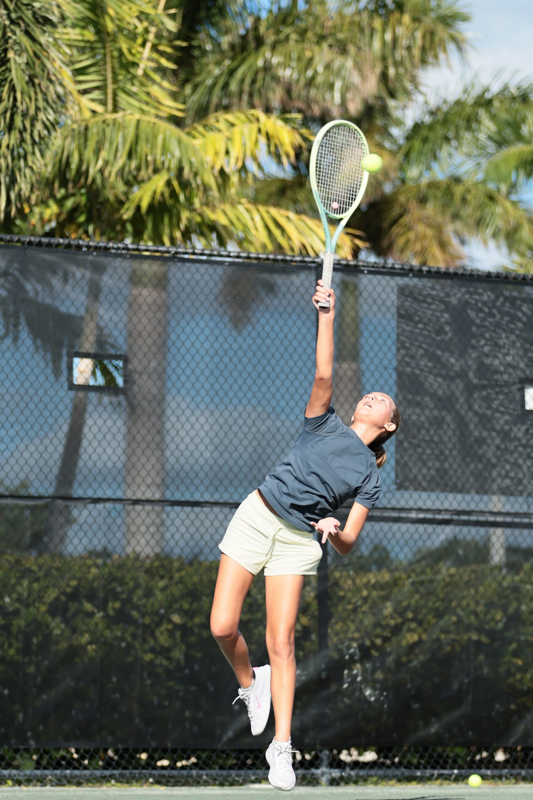 Young female tennis player hitting tennis ball