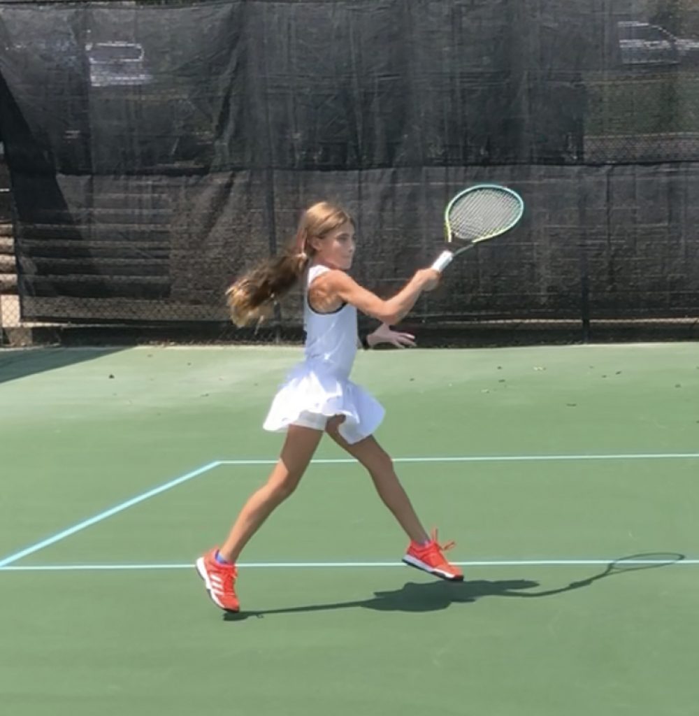 Young female tennis player with red tennis shoes