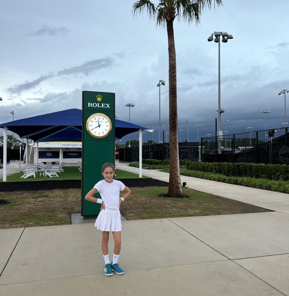 Youth posing infront of Rolex sign outside