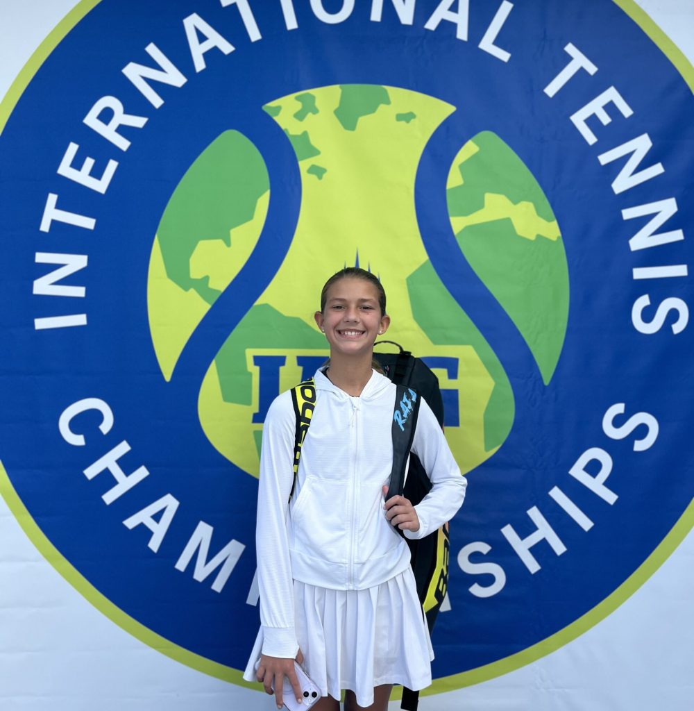 Young tennis player next to international tennis championships sign