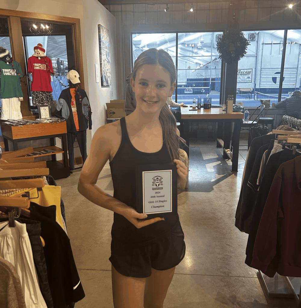 Young female tennis player holding award